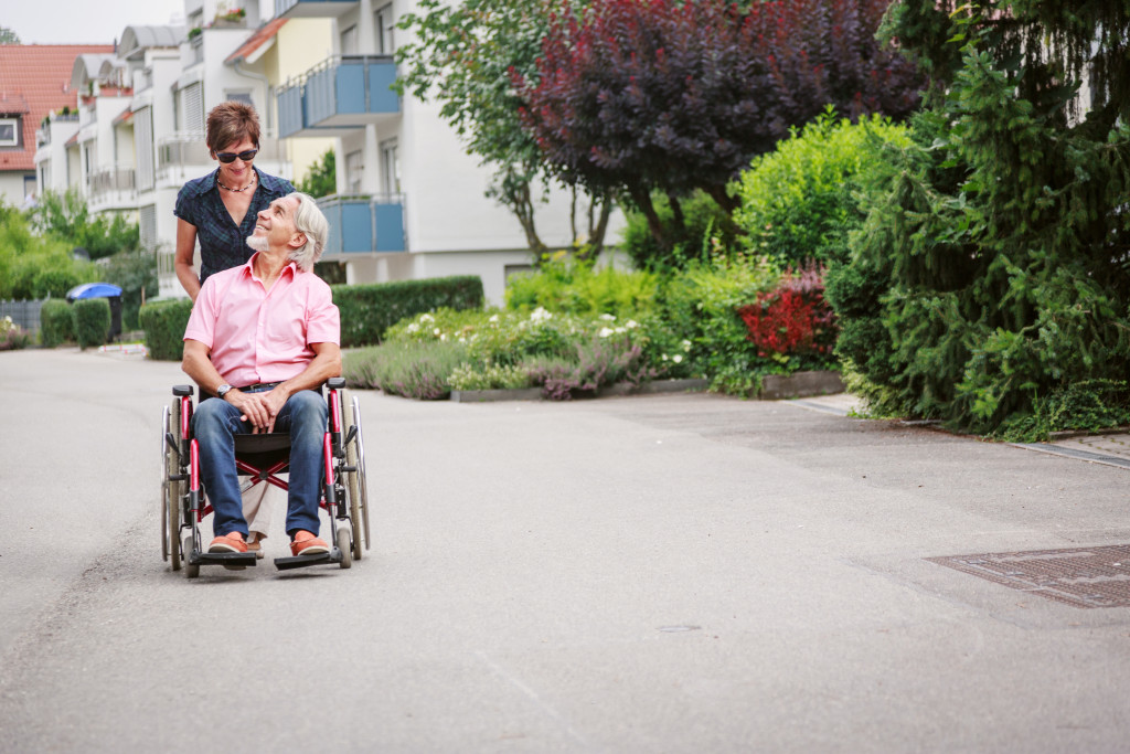 A caretaker helping out a senior in wheelchair