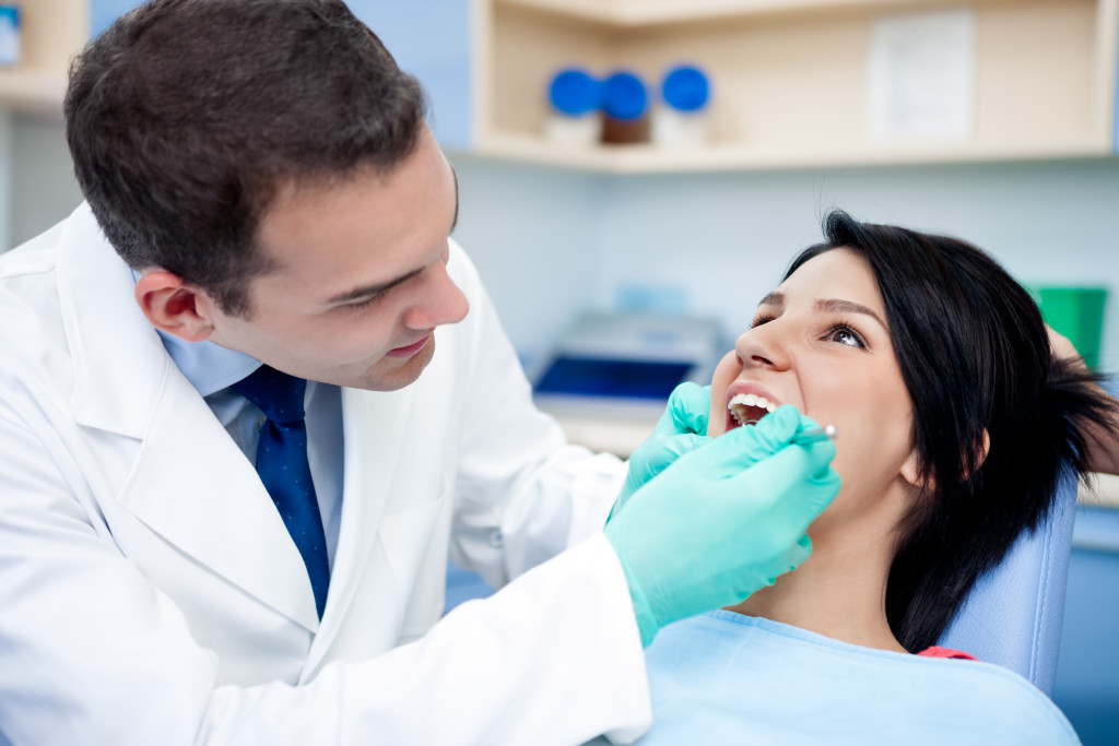 dentist checking patient's mouth
