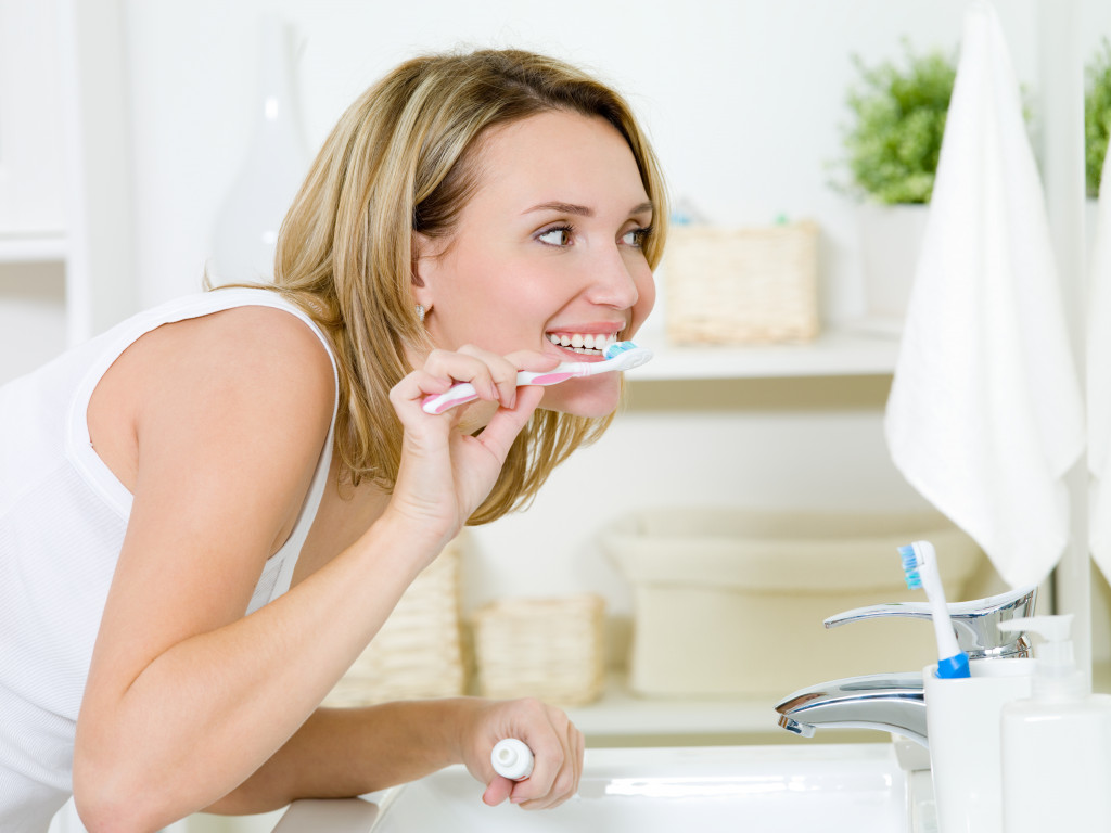 beautiful woman in the restroom brushing her teeth