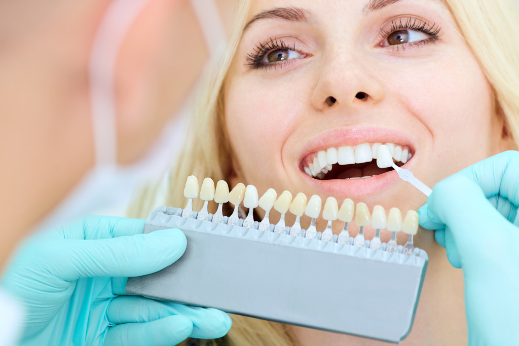 dentist choosing a color for woman's implants