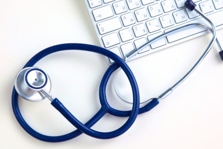 Stethoscope beside laptop keyboard