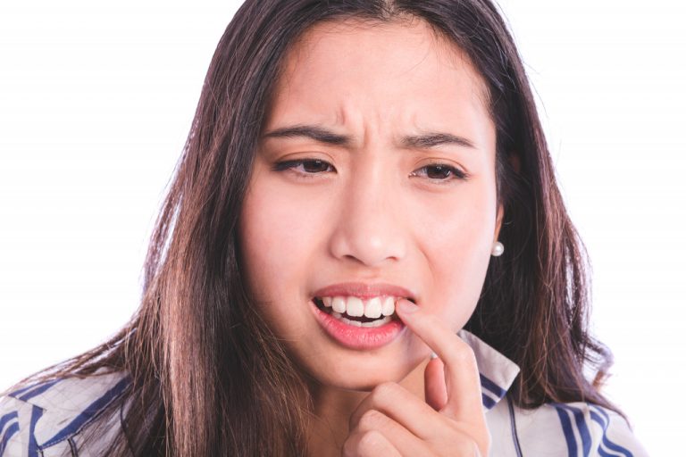 woman touching her teeth