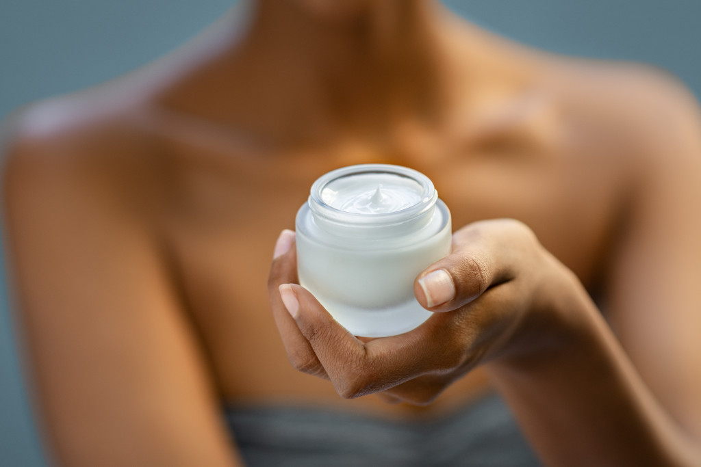 woman hands holding face lotion