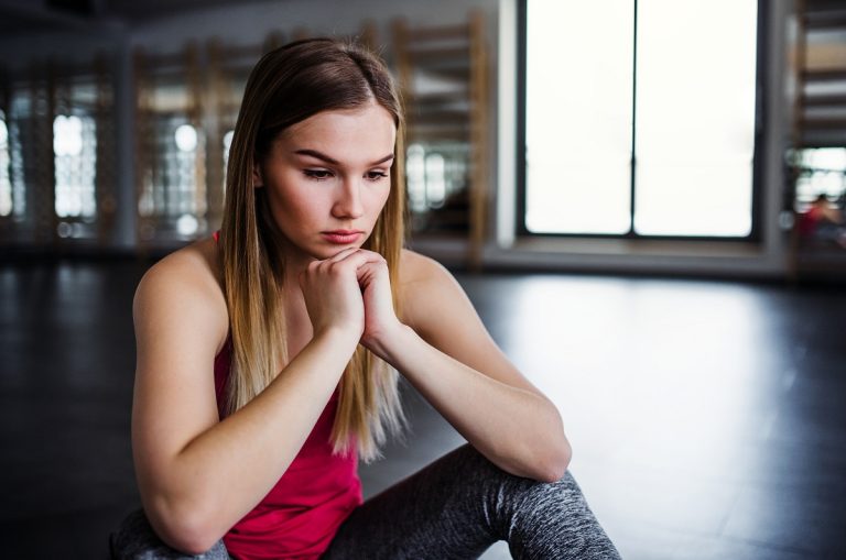 frustrated woman sitting in a gym