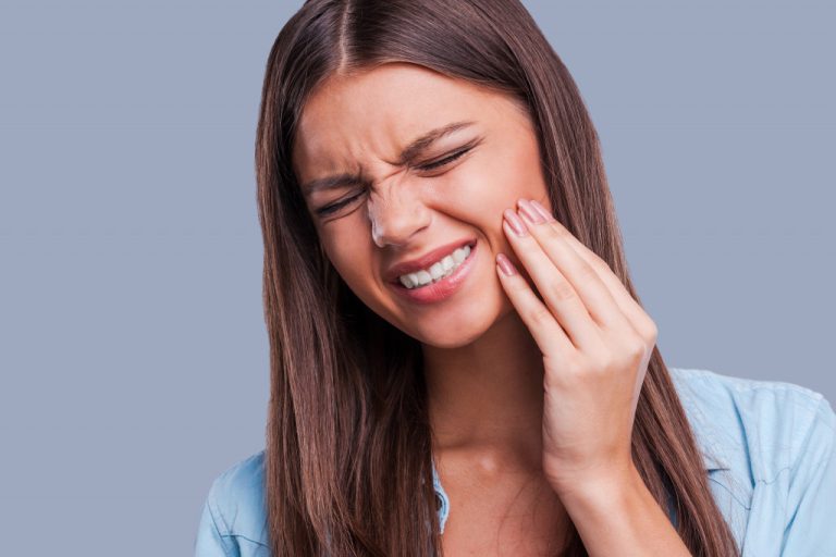 A woman holding her cheek because of toothache
